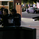 Dallas police move to detain a driver near the area where snipers opened fire on officers.